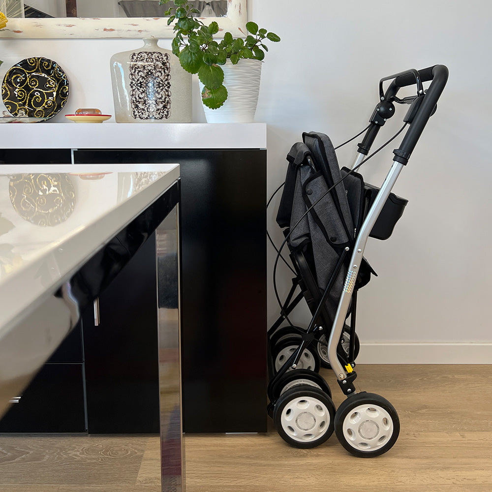 Einkaufsrollator comfort move steht im zusammengeklappten Modus in einer Küche um zu demonstrieren wie wenig Platz dieser verbraucht.
