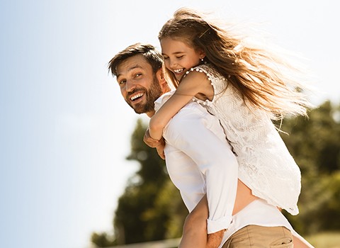 Vater mit Kind auf dem Rücken