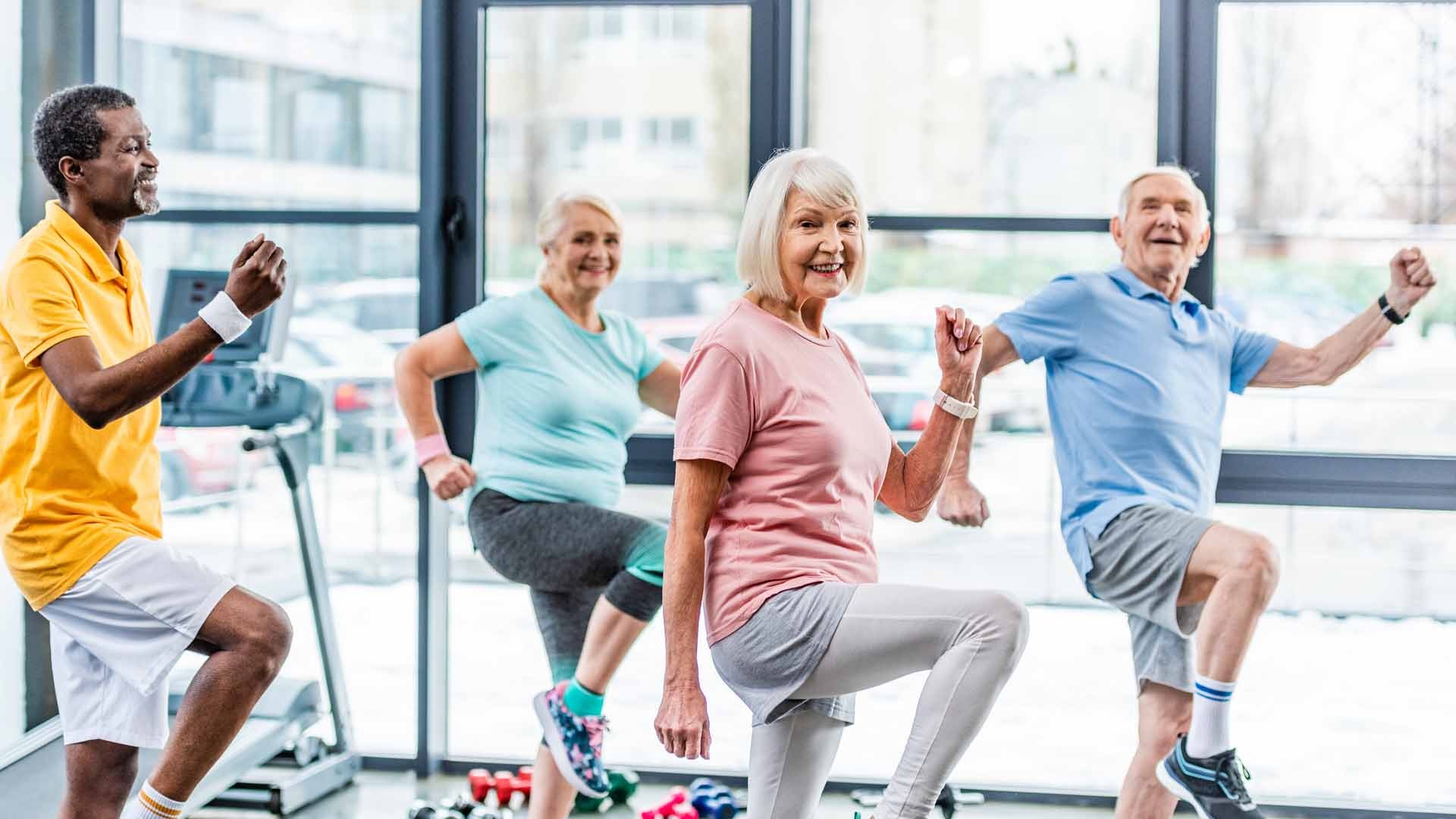 Ältere Menschen beim gemeinsamen Sport im Sportsaal.