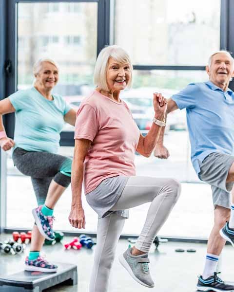 Ältere Menschen beim gemeinsamen Sport im Sportsaal.