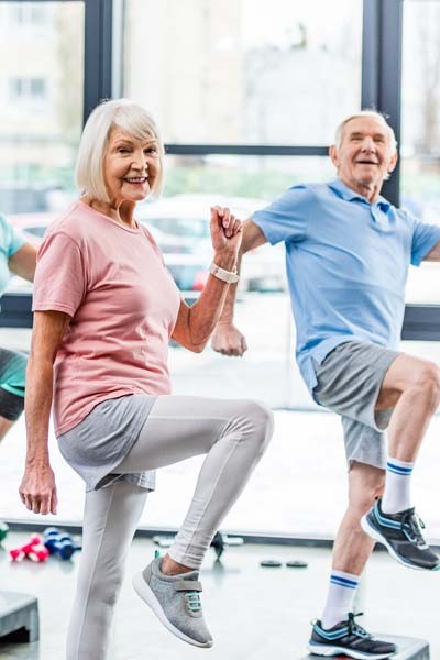 Ältere Menschen beim gemeinsamen Sport im Sportsaal.