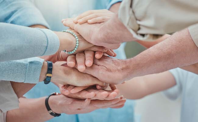 Mehrere übereinandergelegte Hände.