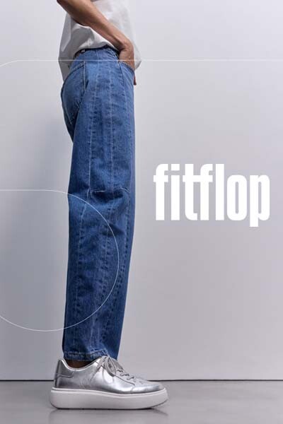 Model in Jeans mit FitFlop Schuhen aus der Herbst-Winter-Kollektion, seitlich Schuh-Detail und FitFlop Logo.