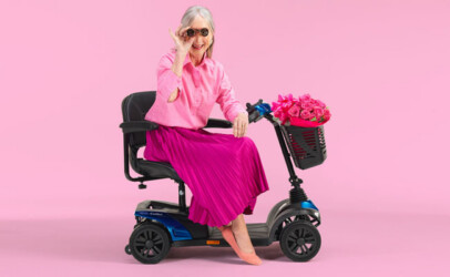 Elegant gekleidete Dame sitzt auf einem Mobilitäts-Scooter.
