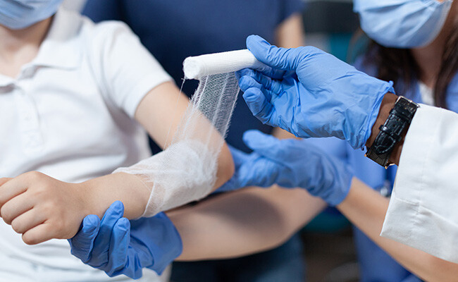 Arzt versorgt Wunde.