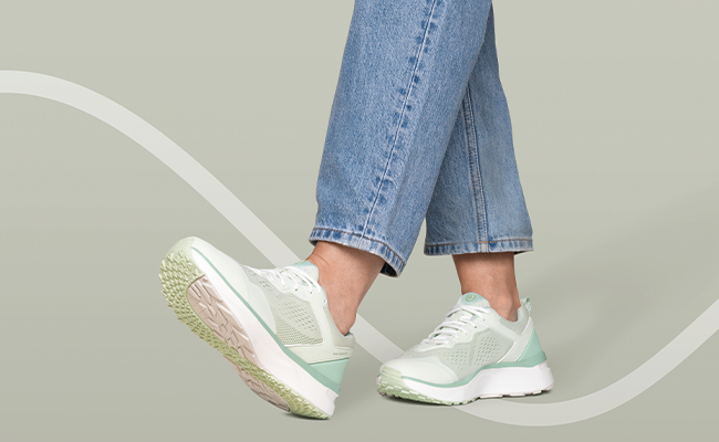 Person trägt hellgrüne Joya Sneaker mit dämpfender Sohle und Jeans beim Gehen