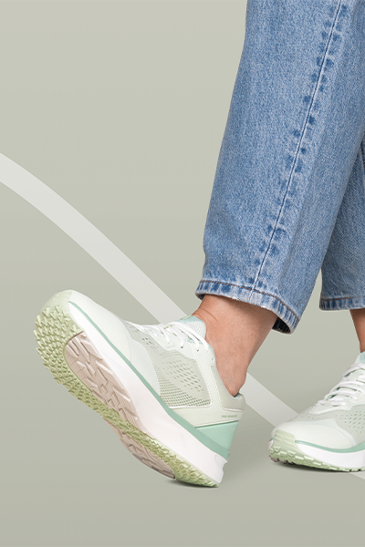 Person trägt hellgrüne Joya Sneaker mit dämpfender Sohle und Jeans beim Gehen