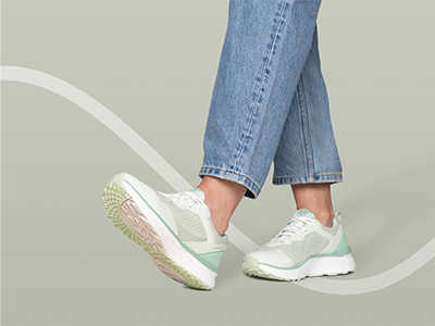 Person trägt hellgrüne Joya Sneaker mit dämpfender Sohle und Jeans beim Gehen